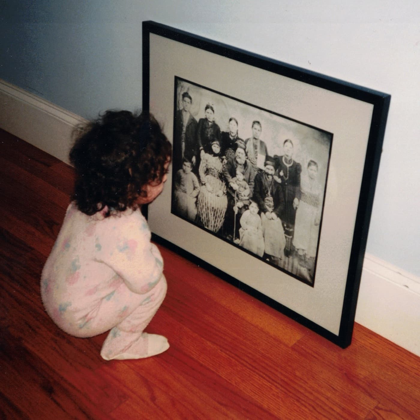 A child looking at a framed portrait of her Armenian ancestors